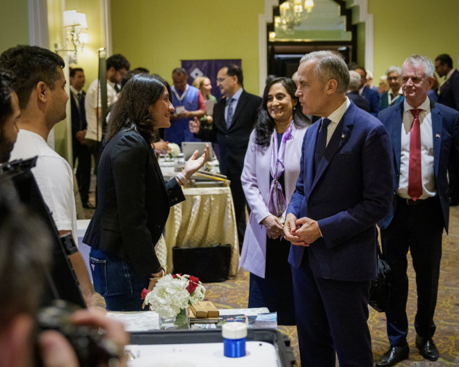 Photo of Prime Minister Carney and Minister Anand meeting university representatives in Mumbai, India.